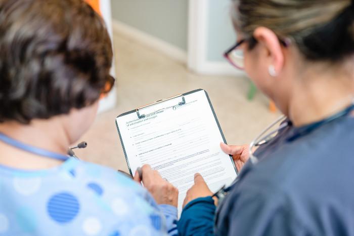 two medical providers looking at a clipboard
